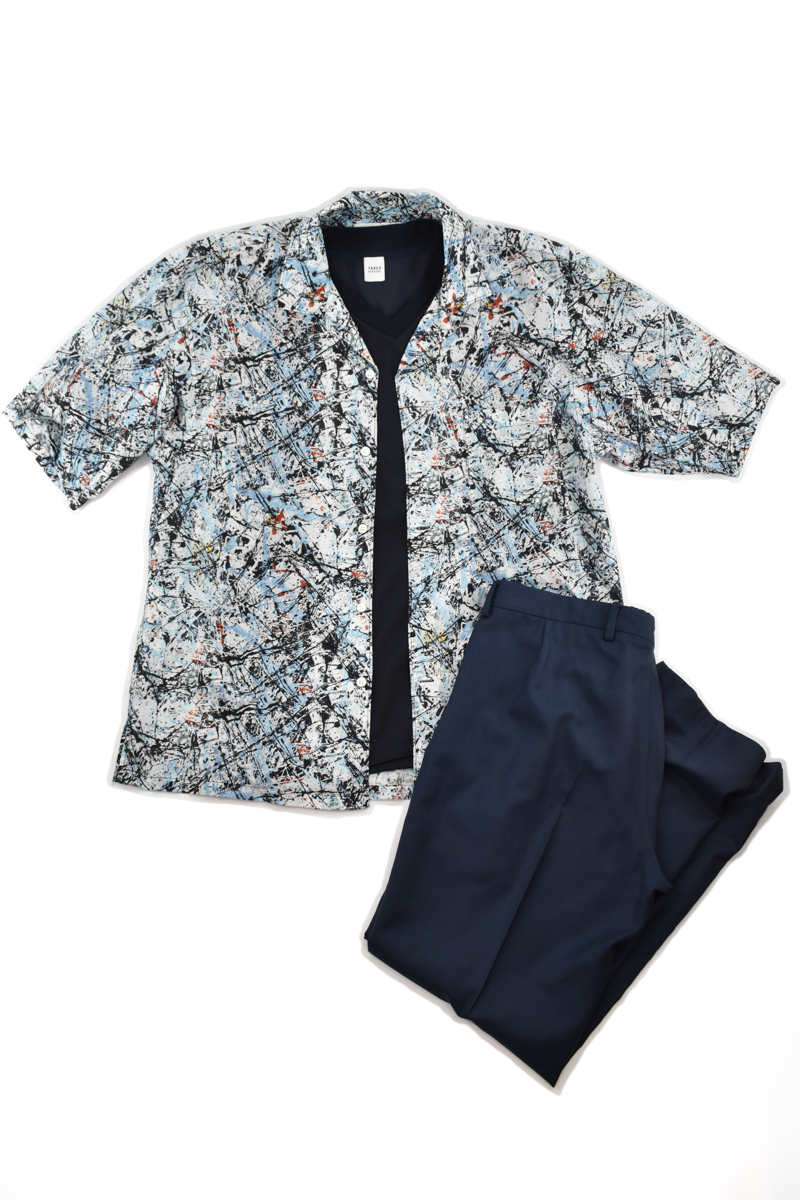 柄のシャツを主役に、シンプルなVネックTシャツとネイビースラックスで上品にまとめたカジュアルコーデ。